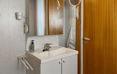 a bathroom with a white sink and a wooden cabinet at Beautiful Home In Vistdal With Wifi in Myklebostad