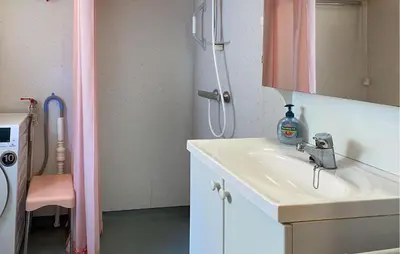 a bathroom with a sink and a washing machine at Beautiful Home In Vistdal With Wifi in Myklebostad