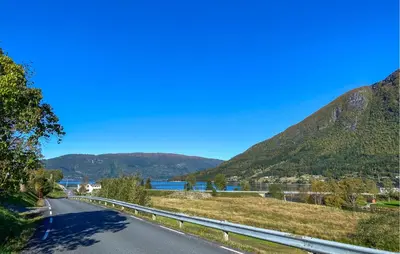a road in the mountains next to a lake at Beautiful Home In Vistdal With Wifi in Myklebostad
