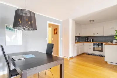a dining room with a table and a kitchen at Beautiful 2-bedroom apartment in Bergen