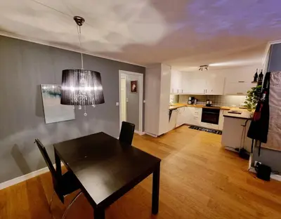 a living room with a table and a kitchen at Beautiful 2-bedroom apartment in Bergen