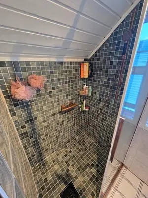 a bathroom with a shower with a tiled wall at Room in Trondheim, Heimdal, Lundåsen - Bus to town every 5 minutes in Trondheim