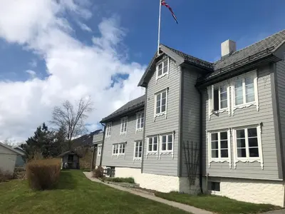 a gray house with a flag on top of it at Grey Lodge in Isfjorden