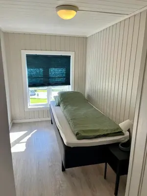 a small bedroom with a bed and a window at Grey Lodge in Isfjorden