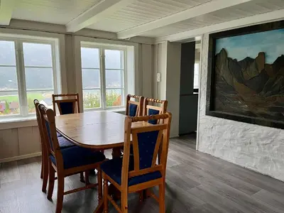 a dining room with a wooden table and chairs at Grey Lodge in Isfjorden