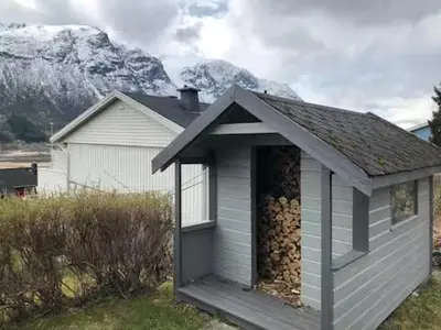 a building with a pile of fire wood at Grey Lodge in Isfjorden