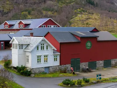 a red and white barn with solar panels on it at Jordeplegarden Apartments in Tønjum