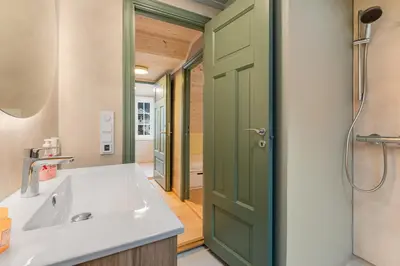a bathroom with a sink and a green door at Jordeplegarden Apartments in Tønjum