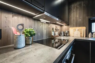 a kitchen with wooden walls and a counter with a sink at Hemsedal ski in ski out, modern comfort by the slopes in Hemsedal