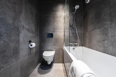 a bathroom with a tub and a toilet and a shower at Hemsedal ski in ski out, modern comfort by the slopes in Hemsedal