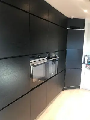 a kitchen with black cabinets and a stove at Townhouse with 4 bedrooms near Sørstrand