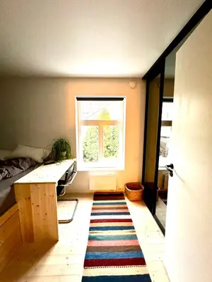 a room with a table and a window and a rug at Charming in the center of Hamar in Hamar