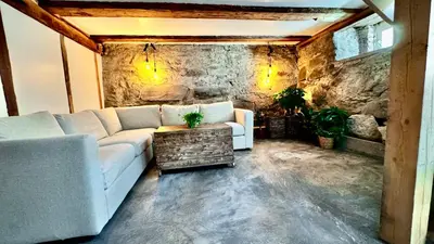 a living room with a couch and a stone wall at Charming in the center of Hamar in Hamar