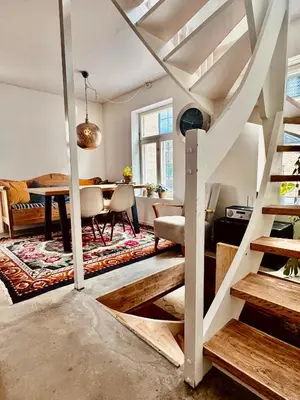 a living room with a staircase and a dining room at Charming in the center of Hamar in Hamar