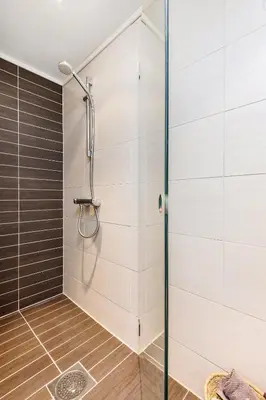 a shower stall with a glass door in a bathroom at Charming in the center of Hamar in Hamar