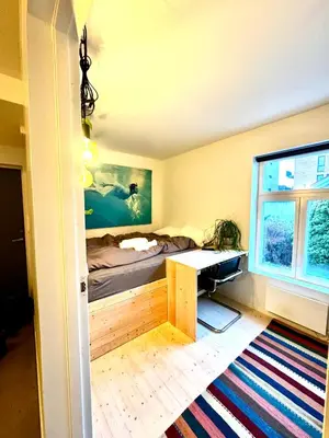 a bedroom with a bed and a desk and a window at Charming in the center of Hamar in Hamar