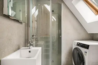 a bathroom with a sink and a washing machine at Bergen Villa - Charming 3 Bedroom with Views! in Bergen