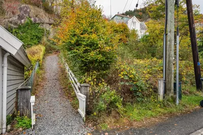 a gravel road next to a house next to a hill at Bergen Villa - Charming 3 Bedroom with Views! in Bergen