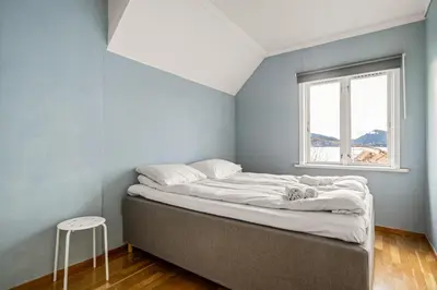 a bed in a room with a window and a stool at Bergen Villa - Charming 3 Bedroom with Views! in Bergen