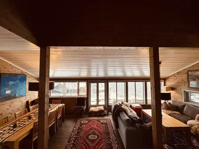 a living room with a couch and a large window at Familiehytte med fantastisk beliggenhet i Vestlia in Geilo