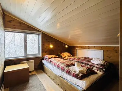 a bedroom with a bed in a wooden cabin at Familiehytte med fantastisk beliggenhet i Vestlia in Geilo