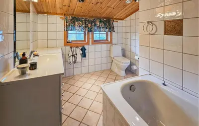 a bathroom with a tub and a toilet and a sink at 4 Bedroom Gorgeous Home In Rjukan in Rjukan
