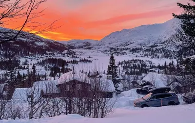 a car parked in the snow at sunset at 4 Bedroom Gorgeous Home In Rjukan in Rjukan