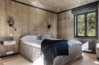 a bedroom with a bed in a room with wooden walls at Bo På Norefjell Rett Ved Alpint Og Langrenn in Noresund