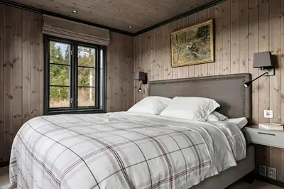 a bedroom with a large bed with wooden walls at Bo På Norefjell Rett Ved Alpint Og Langrenn in Noresund