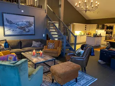 a living room with couches and chairs and a staircase at Panoramic Apartment In The Heart Of Beitostølen in Beitostøl