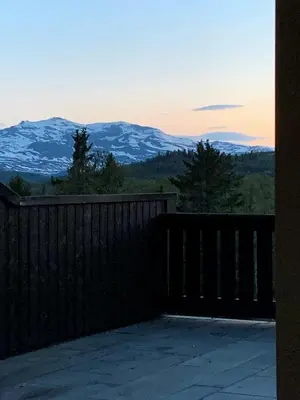 a view of snow capped mountains from a fence at Panoramic Apartment In The Heart Of Beitostølen in Beitostøl