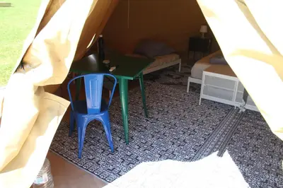 a table and a chair in a tent at Alpakkaparken Glamping med parktilgang