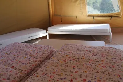a small room with two beds and a window at Alpakkaparken Glamping med parktilgang