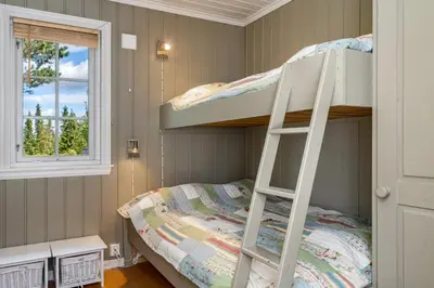 a bunk bed in a room with a ladder at Fjellkos, mountain cabin in Gol in Gol
