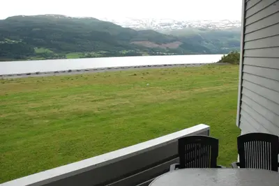 a porch with chairs and a view of a lake at Fleischer's Motel in Vossevangen