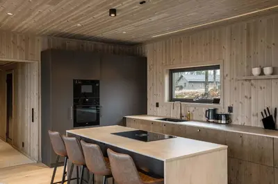 a kitchen with a counter with chairs in it at Trysilfjell hytteområde 2115 by Vacation Trysil in Trysil