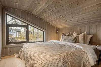 a bedroom with a large bed and a window at Trysilfjell hytteområde 2115 by Vacation Trysil in Trysil