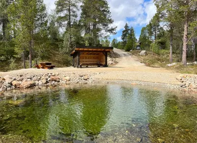 a cabin next to a body of water at Cozy family cabin at Hovden in Bykle