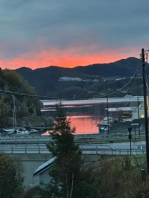 a sunset over a body of water with boats at Aurora Bliss - Waterfront Jacuzzi & Sauna near Bergen in Askøy
