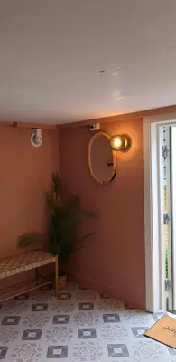 a room with a bench and a mirror on the wall at Cozy bedroom & basement with amenities in Odda