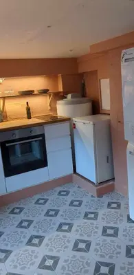 a small kitchen with a stove and a microwave at Cozy bedroom & basement with amenities in Odda