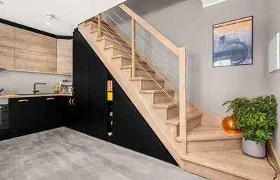 a wooden staircase in a room with a kitchen at Trondheim's smallest detached house in the middle of the city centre! in Trondheim