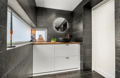 a bathroom with white cabinets and a mirror at Trondheim's smallest detached house in the middle of the city centre! in Trondheim
