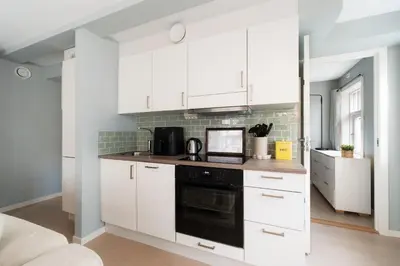 a kitchen with white cabinets and a black oven at Central apartement in Kristiansund in Kristiansund
