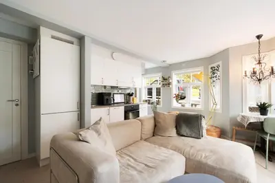 a living room with a couch and a kitchen at Central apartement in Kristiansund in Kristiansund