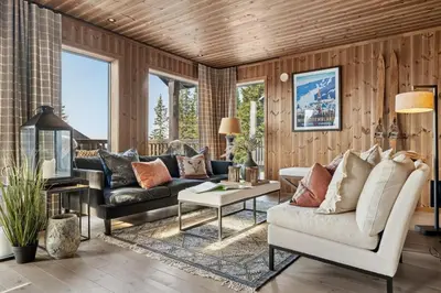 a living room with a couch and a table at Large family cabin at Hafjell with ski in-ski out in Hafjell