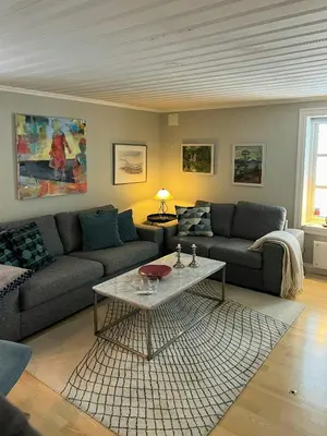 a living room with a couch and a table at Family Cabin By Lake Mylla With Private Dock in Lunner