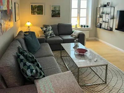 a living room with a couch and a table at Family Cabin By Lake Mylla With Private Dock in Lunner