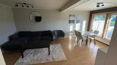 a living room with a couch and a table at Sentral og romslig leilighet på Levanger in Levanger