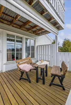 a patio with a table and chairs on a deck at Sentral og romslig leilighet på Levanger in Levanger
